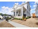 Angled view of a charming two-story home with a stone foundation and a cozy front porch at 2005 Haley Walk, Woodstock, GA 30188