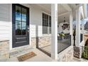 Inviting front porch features stone accents, classic columns, and ample space for relaxing outdoor seating at 2005 Haley Walk, Woodstock, GA 30188