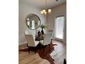 Bright dining area with modern lighting, a round mirror, and a unique cowhide rug at 216 Eping Dr, Stockbridge, GA 30281