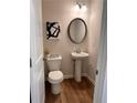 Charming half bath features wood-look floors, modern fixtures and stylish décor at 216 Eping Dr, Stockbridge, GA 30281