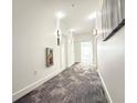 A carpeted hallway with neutral walls, sconce lighting, and a fire extinguisher at 3655 Peachtree Ne Rd # 304, Atlanta, GA 30319