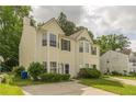 Inviting two-story home with tidy landscaping, neutral yellow siding, and classic window shutters at 5680 Hampton Ct, Atlanta, GA 30349