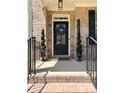 Close-up of a charming front door with decorative wreath, potted spiral topiaries, and elegant house number display at 4736 Landing Water Path, Buford, GA 30519