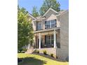 Beautiful front porch with brick stairs, columns, black railings, and seating, perfect for relaxing outdoors at 4736 Landing Water Path, Buford, GA 30519