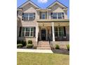 Inviting front porch with brick stairs, black railings, columns, and a well-maintained lawn and landscaping at 4736 Landing Water Path, Buford, GA 30519