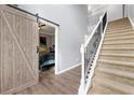 Bright foyer with staircase, elegant railing, and an opening to a bedroom with barn door at 1892 Ivy View Walk, Loganville, GA 30052