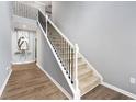 Elegant staircase featuring a white handrail, black metal spindles, and carpeted steps to the second story at 1892 Ivy View Walk, Loganville, GA 30052
