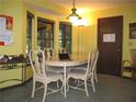 Bright dining room with a light-colored table set for six, featuring a bay window and overhead lighting at 2494 Bronco Trl, Duluth, GA 30096