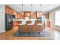 This warm kitchen has wood cabinets, stainless appliances, granite countertops and a stylish island with bar stool seating at 55 Little Barley Ln, Grayson, GA 30017