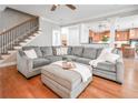 An inviting living room with hardwood floors, a comfortable gray sectional sofa, and a view into the open-concept kitchen at 55 Little Barley Ln, Grayson, GA 30017