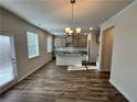 Open-concept kitchen with modern pendant lighting, gray cabinets, stainless appliances, and wood flooring at 3964 Riverchess Lot#157 Sw Dr, Atlanta, GA 30331