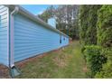 Side view of a light blue home, showcasing lush landscaping and a well-maintained lawn at 4585 Post Ridge Ln, Lithonia, GA 30038
