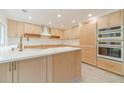 Bright kitchen featuring natural wood cabinetry, quartz countertops, stainless steel appliances, and a modern island at 1349 Mckinsey Rdg, Loganville, GA 30052