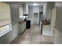 Compact kitchen with wood counters, white cabinets, and a tile floor and backsplash at 2076 Garden Cir, Decatur, GA 30032