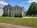 Charming two-story home featuring lush green lawn and inviting curb appeal on a sunny day at 4279 Persian Ct, Snellville, GA 30039