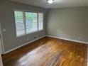 A bedroom with hardwood floors, fresh paint, and a large window at 5703 Kimberly Ln, Norcross, GA 30071
