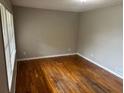 A bedroom with hardwood floors, fresh paint, and a large window at 5703 Kimberly Ln, Norcross, GA 30071