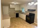 Cozy kitchen with white cabinets, black appliances, and ample counter space at 5703 Kimberly Ln, Norcross, GA 30071