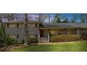 Charming two-story home with a well-manicured front lawn, large tree, landscaped bushes and shrubbery at 1436 Diamond Head Drive Dr, Decatur, GA 30033