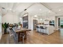 Open-concept dining room with modern light fixtures, a wooden table, and views into the kitchen at 2721 Old Concord Se Rd, Smyrna, GA 30082