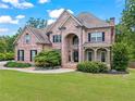 Beautiful brick home featuring a manicured lawn, and stately architectural details at 7493 Elderberry Dr, Douglasville, GA 30135