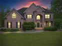 Charming brick home with a well-manicured lawn and mature landscaping at twilight at 7493 Elderberry Dr, Douglasville, GA 30135