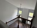 View from staircase of spacious living room featuring fireplace and large windows at 8850 Grappe Trace, Suwanee, GA 30024