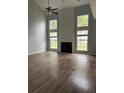 Bright and spacious living room with fireplace, tall windows, and hardwood floors at 8850 Grappe Trace, Suwanee, GA 30024