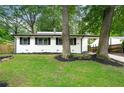 Charming one story home with black trim, a green lawn and mature trees at 2828 Cloverhurst Dr, Atlanta, GA 30344