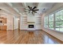 Open-concept living room with coffered ceilings, fireplace, custom built-ins, and hardwood floors at 3599 Centerville Rosebud Rd, Snellville, GA 30039