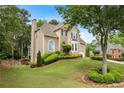 Spacious suburban home with large front lawn, manicured bushes and trees, and an attached garage at 3640 Ridgeway Ter, Suwanee, GA 30024