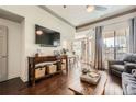 Open-concept living room with hardwood floors, a large screen TV, and balcony access at 3777 Peachtree Ne Rd # 1335, Atlanta, GA 30319