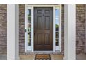 Close-up of the classic front door framed by stone accents and decorative sidelights, creating a warm entrance at 3798 Kirkwood Nw Run, Kennesaw, GA 30144