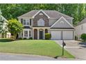 Traditional two-story home boasts a well-kept lawn, double garage, and inviting curb appeal at 3798 Kirkwood Nw Run, Kennesaw, GA 30144