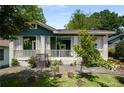 A cozy home with a green exterior, a charming front porch with white railings, and surrounding greenery at 1545 Montreat Sw Pl, Atlanta, GA 30311