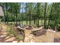 Cozy backyard fire pit area surrounded by mature trees and scenic golf course views at 232 Heron Pointe Vw, Canton, GA 30114