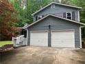Exterior shot showcasing the gray siding and attached two-car garage of the home at 486 Victoria Rd, Woodstock, GA 30189