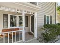 Charming porch with seating, dark shutters, and decorative white columns and railing at 1493 Martin Nash Sw Rd, Lilburn, GA 30047