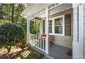 Charming front porch features neutral colors, a pair of chairs, and decorative columns at 1493 Martin Nash Sw Rd, Lilburn, GA 30047