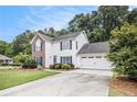 View of a two-story home with blue shutters, an attached garage, and green lawn at 175 Fenwyck Commons, Fayetteville, GA 30214