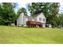 Two-story home featuring a lush green lawn, a charming wooden deck, and mature trees at 701 Rockingham Ct, Woodstock, GA 30189