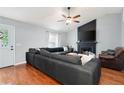 Spacious living room with hardwood floors, fireplace, ceiling fan, and comfortable seating at 701 Rockingham Ct, Woodstock, GA 30189