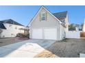Rear view of home showcasing the siding and two-car garage with ample parking space at 7492 Ferrara Dr, Lithonia, GA 30058