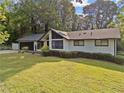 Exterior view of a cozy, one-story home with a lush green lawn and mature trees at 1759 Kimberly Sw Dr, Marietta, GA 30008