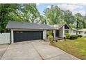 View of one-story home featuring a well-maintained lawn, inviting entryway, and attached garage at 1759 Kimberly Sw Dr, Marietta, GA 30008