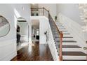Elegant foyer with hardwood floors, staircase with wrought iron railings, and abundant natural light at 7933 Heathmore Dr, Fairburn, GA 30213