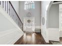 Bright foyer with hardwood floors, staircase, transom window, and a decorative mirror at 7933 Heathmore Dr, Fairburn, GA 30213
