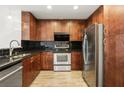 Well-equipped kitchen with stainless steel appliances, dark cabinetry, and a sleek black tile backsplash at 860 Peachtree Ne St # 2209, Atlanta, GA 30308