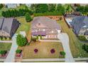 Aerial view of a brick home with manicured lawn, mature landscaping, and a long drive in a suburban neighborhood at 1074 Nash Springs Cir, Lilburn, GA 30047