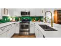 A kitchen featuring stainless steel appliances, white cabinets and countertops, and an emerald backsplash at 1635 Briarcliff Rd # 8, Atlanta, GA 30306